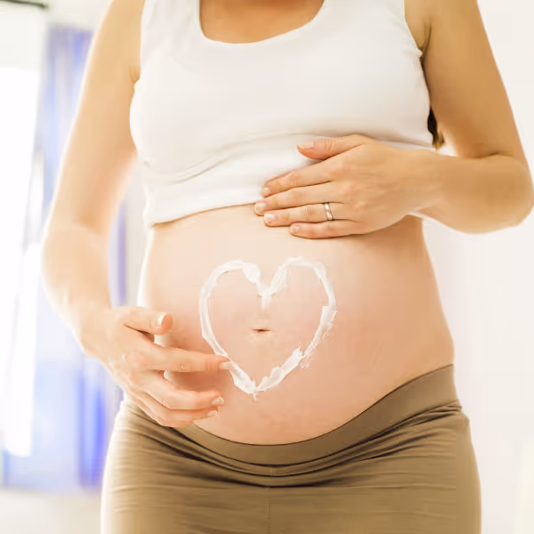 Gravid mage med et hjerte tegnet i krem