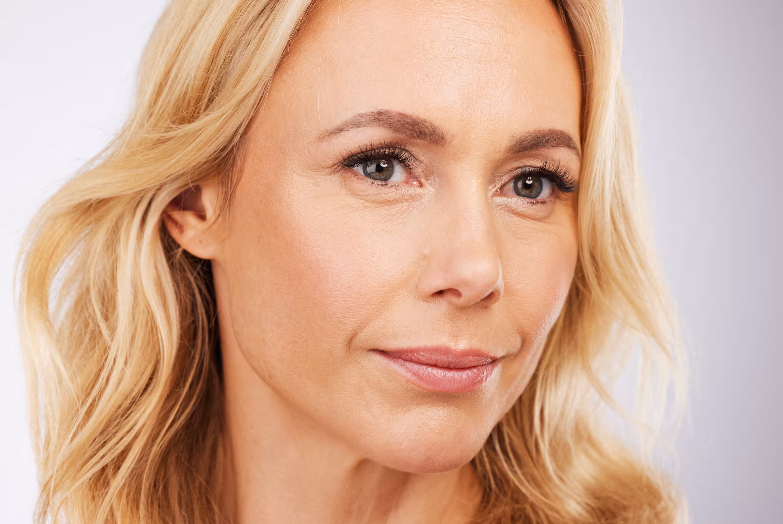 Nærbilde av en blond kvinne med glatt hud